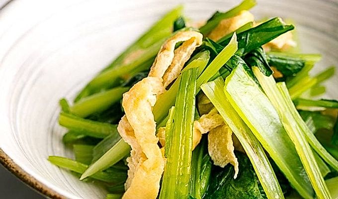 Biała japońska miska ceramiczna zawierająca Simmered Fried Tofu i Greens.