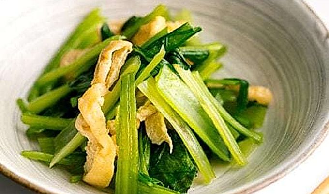 Biała japońska miska ceramiczna zawierająca Simmered Fried Tofu i Greens.
