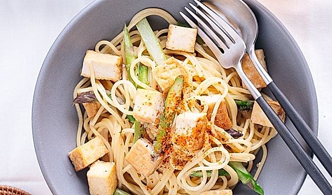 Серая миска, содержащая сливочную пасту мисо с тофу и спаржей.