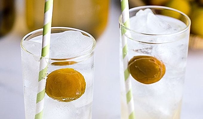 Высокие стаканы, содержащие сидр с сиропом умэ и компот умэ.