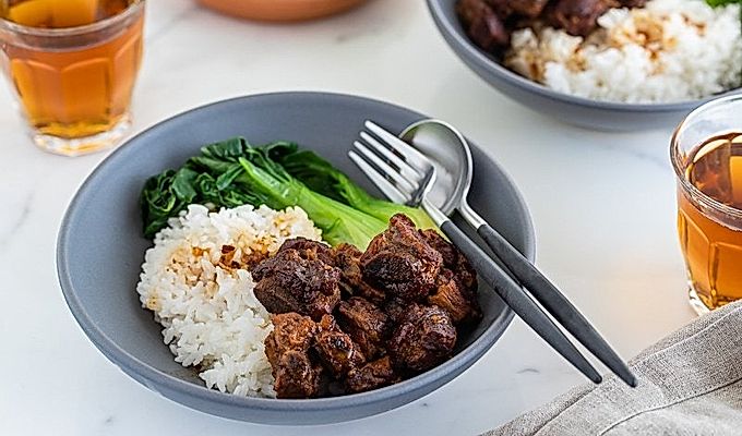Ребрышки с медом быстрого приготовления подаются с рисом и бок-чой на пару в серой керамической миске.