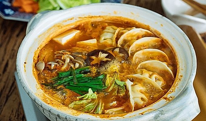 Isang donabe hot pot na naglalaman ng kimchi gyoza hot pot stew.