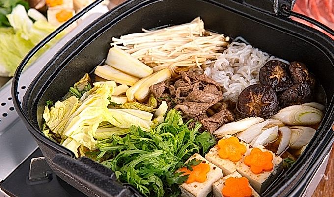 Nagluto si Sukiyaki sa isang cast iron pot.