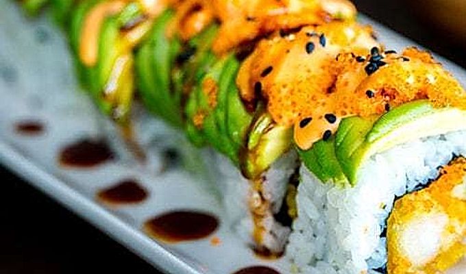 Dragon Roll içeren beyaz bir tabak.