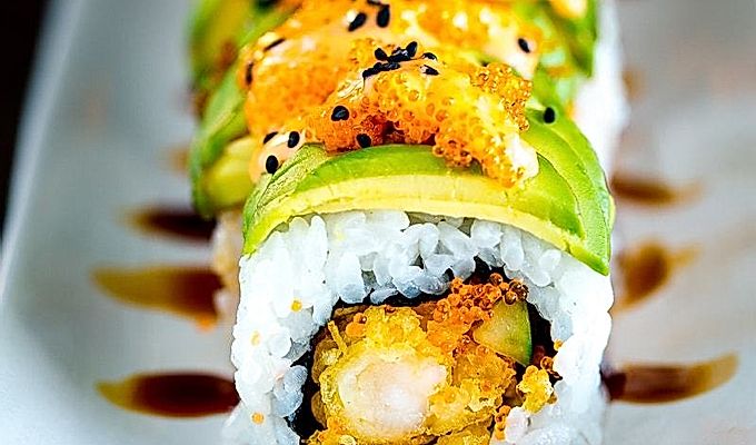 Dragon Roll içeren beyaz bir tabak.