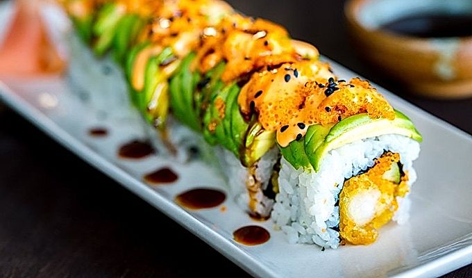 Dragon Roll içeren beyaz bir tabak.