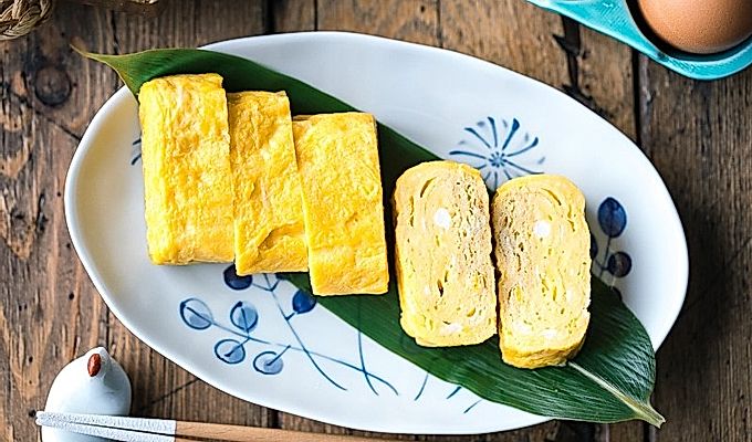 En oval plade indeholdende japansk sødvalset omelet.