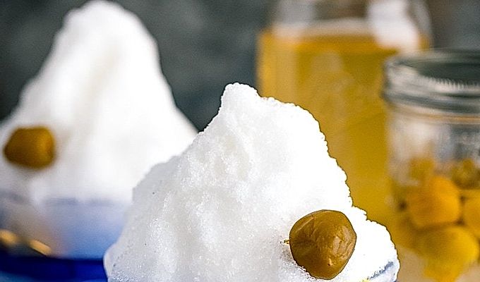 Чаша из синего стекла, содержащая ледяную стружку, сливовый сироп умэ и компот умэ.