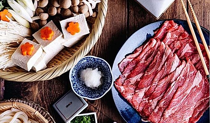 しゃぶしゃぶのテーブルセットアップ-土鍋鍋、野菜、肉、うどん、ディップサ…