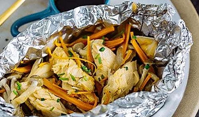 En plade indeholdende laks i folie med ponzu-sauce på siden.