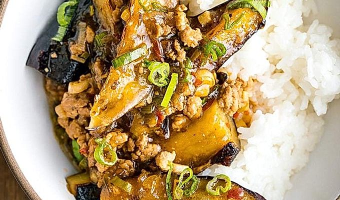 Белая миска с баклажанами Мапо (Мабо Насу) подается с пропаренным рисом.