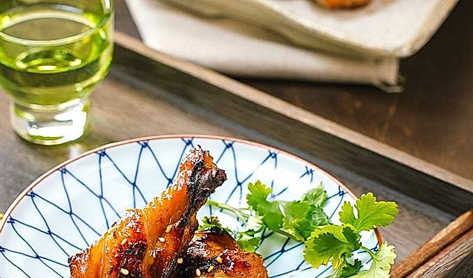 Plat biru dan putih yang mengandungi Sayap Ayam BBQ Manis dan Pedas.