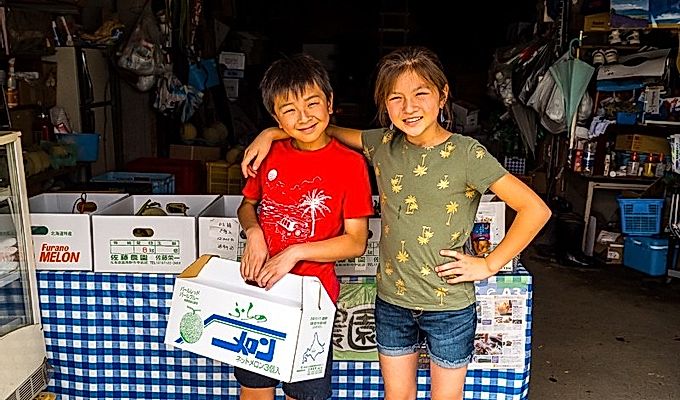 мальчик и девочка с коробками дыни Furano