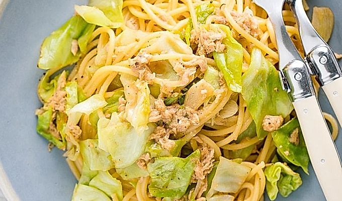 Синяя тарелка с пастой из тунца и капусты по-японски.