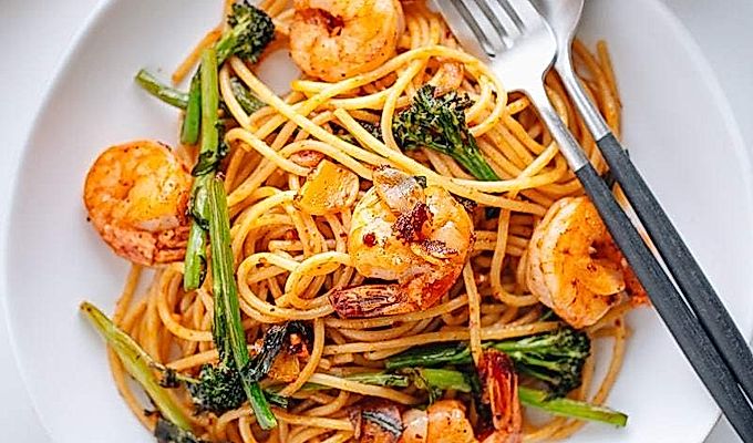 Pinggan putih berisi Pasta Jepun dengan Udang dan Broccolini.