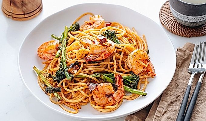 Pinggan putih berisi Pasta Jepun dengan Udang dan Broccolini.