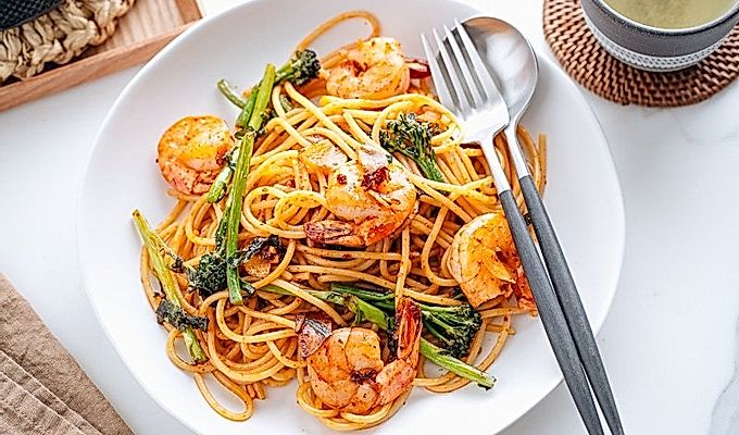 Pinggan putih berisi Pasta Jepun dengan Udang dan Broccolini.