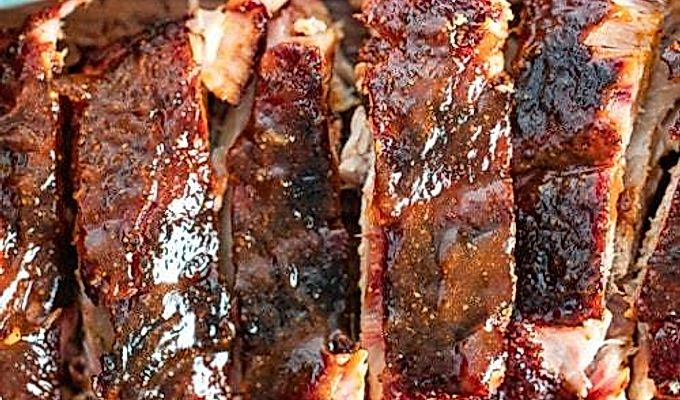 Gerookte baby back ribs met bbq saus.