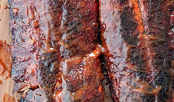 Gerookte baby back ribs met bbq saus.