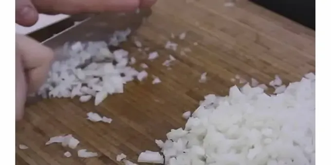 Fregiu la ceba fins que estigui daurada en una paella ben escalfada.