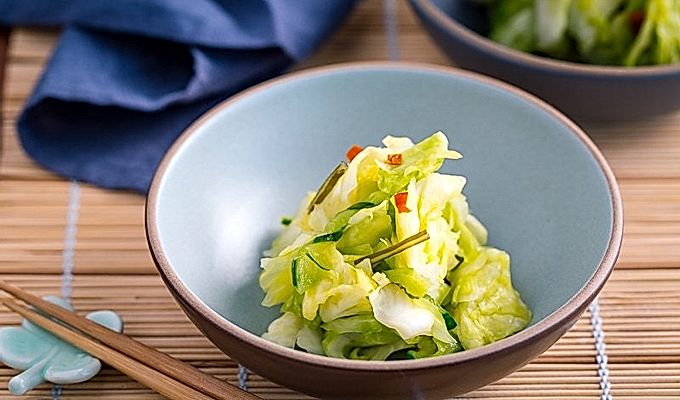 Голубая керамическая миска с маринованной капустой по-японски.