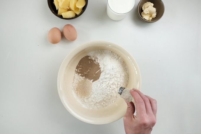 Смешайте дрожжи, соль и сахар с мукой в ​​миске.