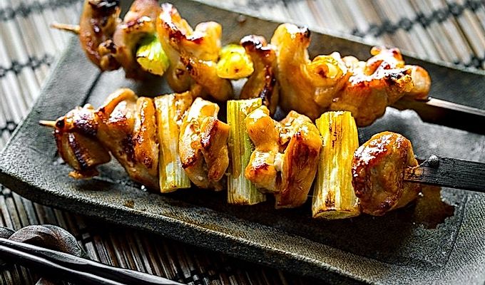Ein Keramikteller mit Yakitori.