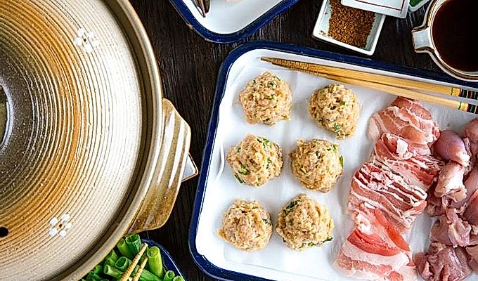 שולחן אוכל מלא במרכיבי Chanko Nabe וסיר חם של Donabe.