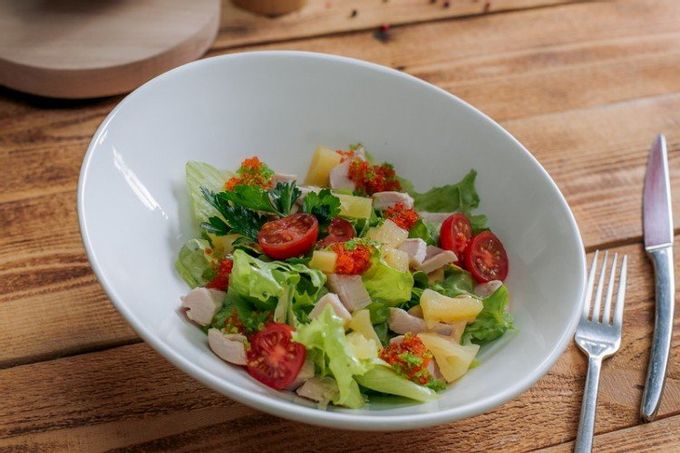 Salad with pineapple, smoked chicken, arugula and cherry tomatoes