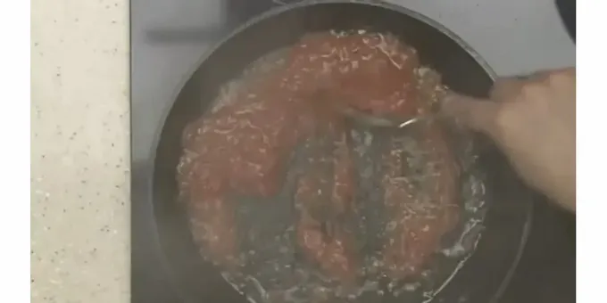 Į pomidorų padažą suberiame susmulkintą česnaką.